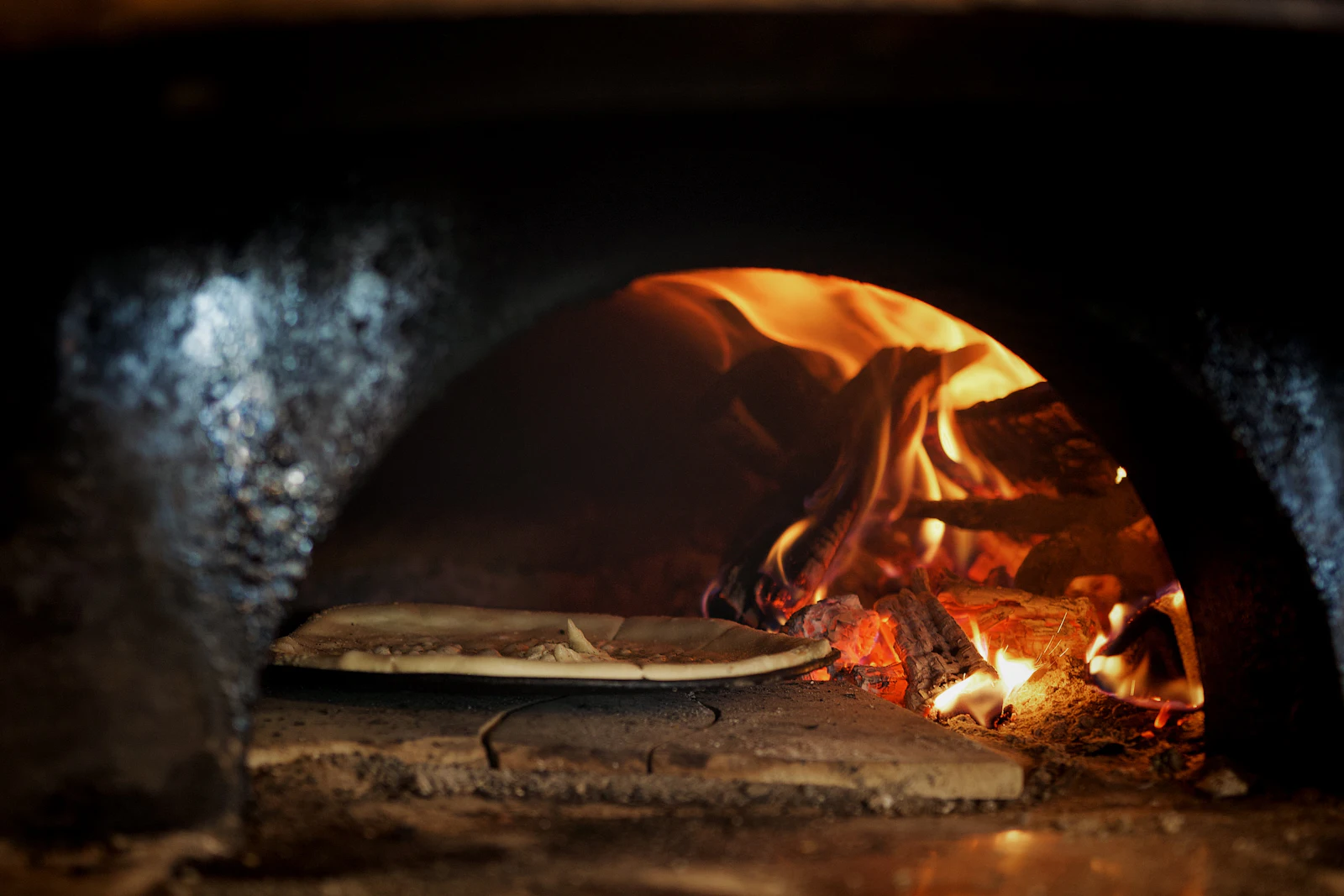 Pizza en cuisson dans les flammes du four